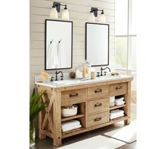 a bathroom with two sinks, mirrors and towels on the counter top in front of it