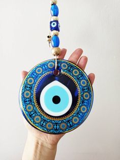 Width of the blue evil eye is 13 cm(5.11 in) Large Round bead is made of glass. Height of the Evil eye wall hanging is 31 cm(12.20 in) This charm is known as mati, Turkish Evil Eye, Turkish Nazar Boncuk and Greek Eye. Evil eye amulet is used as a wall hanging for protection. You can place this large evil eye with rope in your home or office. Evil eye amulet can be a great housewarming gift. For more evil eye hangings, click the link below; https://www.etsy.com/shop/EyeDesignsbyGG?ref=search_shop Bohemian Blue Evil Eye Bracelet For Festival, Handmade Blue Evil Eye Bracelet For Festival, Blue Evil Eye Bracelet For Festivals, Protection Talisman, Evil Eye Wall Hanging, Greek Eye, Turkish Decor, Turkish Eye, Evil Eye Protection