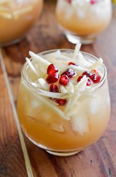 two glasses filled with drinks on top of a wooden table