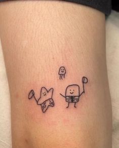 a tattoo on the leg of a person with two small objects in front of them