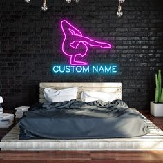 a bed in a room with a neon sign on the wall above it that says custom name