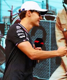 a man holding a microphone in front of a poster