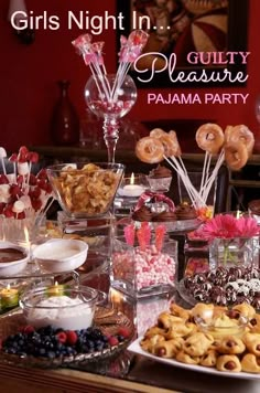 there are many desserts on the table with candles and candy in glass containers next to each other