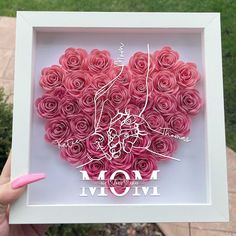 a heart made out of pink roses with the word mom written in white on it