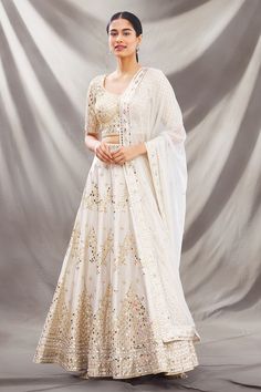 Ivory lehenga with all-over intricate mirror embellishments. Comes with round neckline blouse and dupatta.
Component: 3
Embroidered
Neckline: Round
Sleeve Length: Half
Fabric: Dupion Raw Silk
Color: White
Deep U neck at the back with tie-up
Embroidered dupatta
Closure: 
Blouse: Hook closure at the back
Lehenga: Drawstring with latkans - Aza Fashions Round Neckline Blouse, Intricate Mirror, Ivory Lehenga, Embroidered Lehenga, Embroidered Dupatta, Embroidered Neckline, U Neck, White Silk, Embroidered Silk