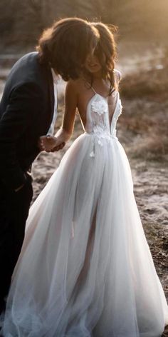 a woman in a white dress standing next to a man wearing a tuxedo