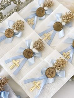 blue and white ribbons with gold crosses are on top of the napkins that have buttons