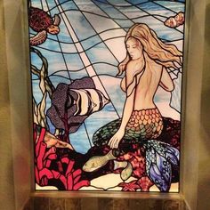 a stained glass window with a mermaid sitting on it