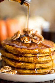 a stack of pancakes with syrup being drizzled on top