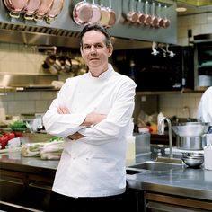 a man standing in a kitchen with his arms crossed