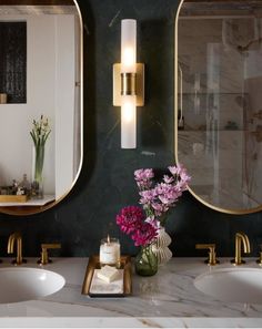 a bathroom with two sinks, mirrors and flowers in vases on the counter top