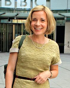 a woman is walking down the street with her purse in hand and smiling at the camera