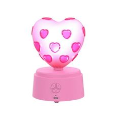 a pink heart shaped light on top of a small device with hearts all over it