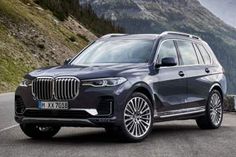 the new bmw x7 suv is driving on a mountain road