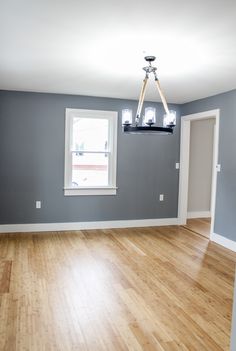 an empty room with hard wood floors and gray walls