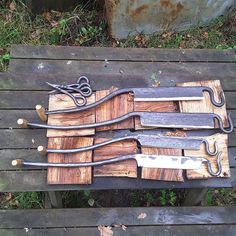 a bunch of knives are sitting on some wood