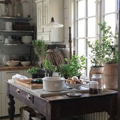 a kitchen filled with lots of pots and pans on top of a wooden table