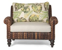 a chair with a pillow on top of it and palm leaves in the back ground