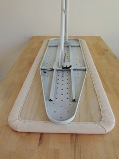 a wooden table topped with a white and gray floor mop