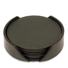 a stack of black leather coasters on a white background