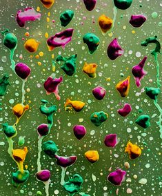 an abstract painting with green, yellow and purple colors on the water droplets that are falling onto the ground