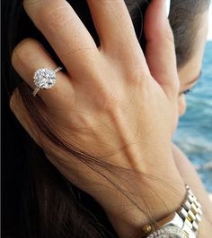 a close up of a person's hand with a diamond ring