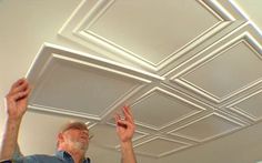 two men are working on an unfinished ceiling