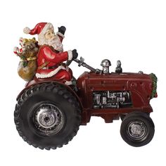 a santa clause riding on the back of a red tractor