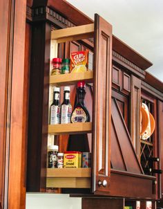 an open cabinet with spices and condiments in it