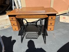 an old sewing machine sitting on top of a wooden table next to a cardboard box