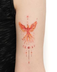 a woman's arm with an orange and red bird tattoo on the left side