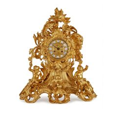 an ornate gold clock with cherubs on the front and sides, against a white background