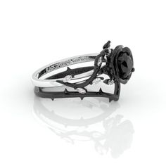 a black and white diamond ring sitting on top of a table