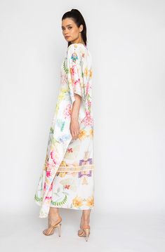 Bring out your inner flower in the Botanica Long Caftan. This gorgeous piece of apparel features delicate flowering patterns, giving you the freedom to show off your unique style. And the airy fabric won’t weigh you down, meaning you can wear your beauty around the clock! Bloom into something special with the Botanica Long Caftan. Printed short caftan Can be worn loose or cinched at the waist Comes with a matching belt as an option for styling Lusciously soft poly-silk blend for ease of care Mac Summer Multicolor Floral Kimono, Summer Multicolor Floral Embroidered Kimono, Summer Floral Embroidered Multicolor Kimono, Spring Floral Print V-neck Kaftan, Bohemian Long Kaftan For Spring, Feminine Beach Kimono For Summer, Spring Bohemian Kaftan With Kimono Sleeves, White Bohemian Maxi Kimono, Bohemian Maxi Kaftan With Floral Print