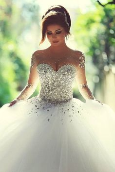 a woman wearing a white wedding dress with sequins on the top and sleeves