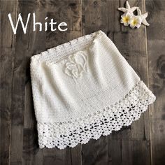 a white crocheted skirt with an embroidered monogram