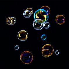 soap bubbles floating in the air on a black background