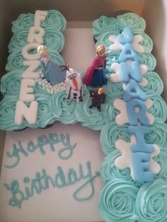 a birthday cake in the shape of a letter with frosting and figurines