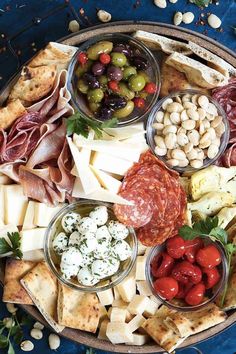 a platter filled with different types of meats, cheeses and other foods