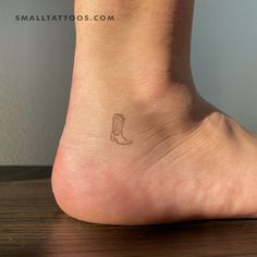 a small foot with a boot tattoo on it