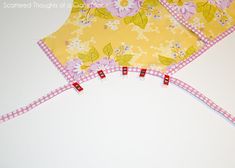 two yellow aprons with pink and white flowers on them sitting next to each other