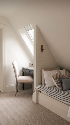 an attic bedroom with white walls and beige carpeted flooring is pictured in this image