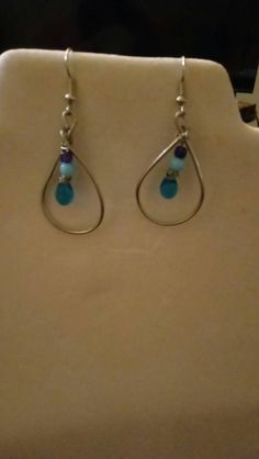 Need to add a unique touch of elegance to your work or party outfit? These earrings have a simple but stylish look to them. The wire loop teardrop and blue dangle beading is very pretty. From the top of the hook to the bottom of the loop measures just short of 2.5 inches long. I use silver plated copper wire for the loop but the ear hooks are hypoallergenic zinc alloy. I love custom orders and would love to make this just for you. I offer just about every color of the rainbow in wire and a few different colors for the beads. Dont be afraid to ask. If I dont have the color you want, I will find it. Silver Wire-wrapped Teardrop Earrings, Blue Teardrop Hoop Earrings With Dangling Beads, Wire Wrapped Teardrop Earrings For Party, Metal Teardrop Beaded Earrings With Ear Wire, Metal Beaded Teardrop Earrings With Ear Wire, Elegant Metal Teardrop Earrings Wire Wrapped, Elegant Metal Teardrop Earrings With Wire Wrapped Detail, Elegant Metal Wire Wrapped Teardrop Earrings, Sterling Silver Teardrop Beaded Earrings With Dangling Beads