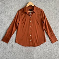 Banana Republic Satin Classic Shirt Orange Sz M Size M Color: Brown Fit & Sizing Size Up For A More Relaxed Look. Hits At The Hip. Product Detail Versatile Cuff Styling. Spread Collar. Long Sleeves With Buttoned Cuffs. Button-Down Front Placket. Back Yoke Seam With Box Pleat. Shirttail Hem. Fabric & Care 97% Polyester, 3% Spandex. Machine Wash. Item #715651 Gr00001233 Brown Spread Collar Tops For Work, Elegant Brown Tops With Collar, Fitted Tops With Spread Collar, Brown Fitted Tops With Spread Collar, Brown Fitted Top With Spread Collar, Classic Brown Blouse For Work, Casual Fitted Blouse With Spread Collar, Classic Brown Blouse For Office, Fitted Casual Blouse With Spread Collar