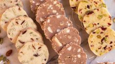 several different types of cookies and pastries on a table with white paper around them