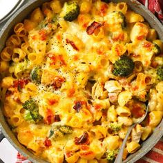 a skillet filled with macaroni and cheese covered in broccoli