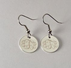 pair of earrings with monogrammed elephant on them