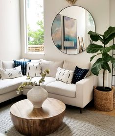 a living room filled with furniture and a large mirror on the wall above it's windows