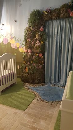 a baby's room decorated in blue and green with pink flowers on the wall