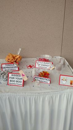 a table topped with lots of food next to a white wall and a sign that says kiss for your boo